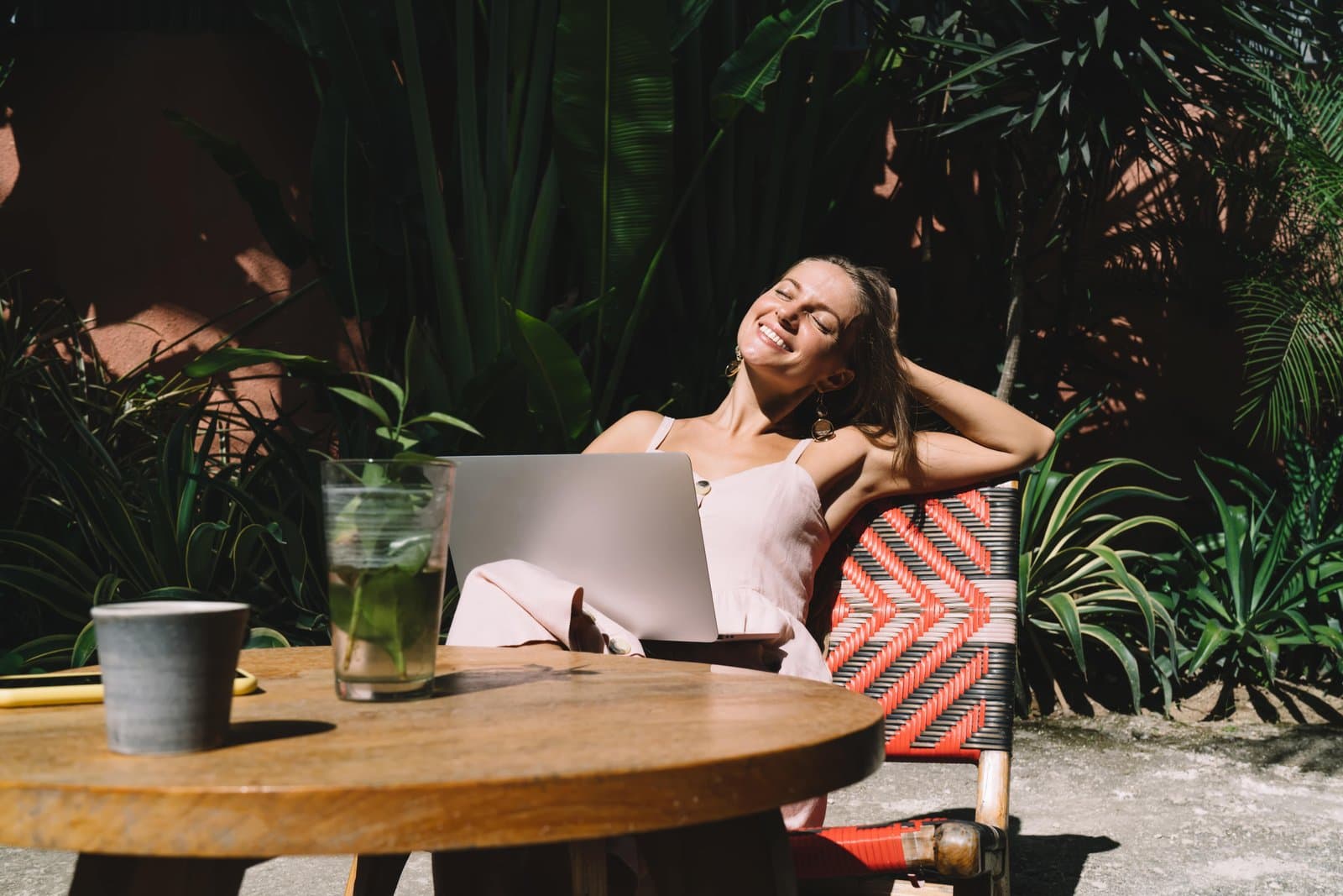 Digitale Nomadin arbeitet am Laptop draußen in einem Café