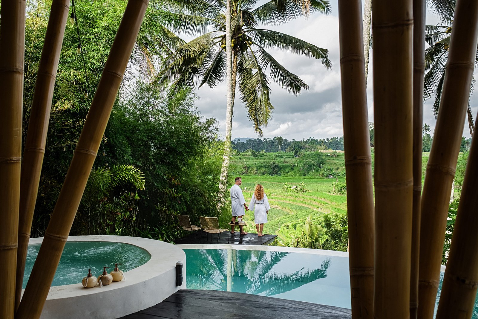 Pärchen schaut von der Veranda ihrer Villa in Bali auf die Reisterrassen